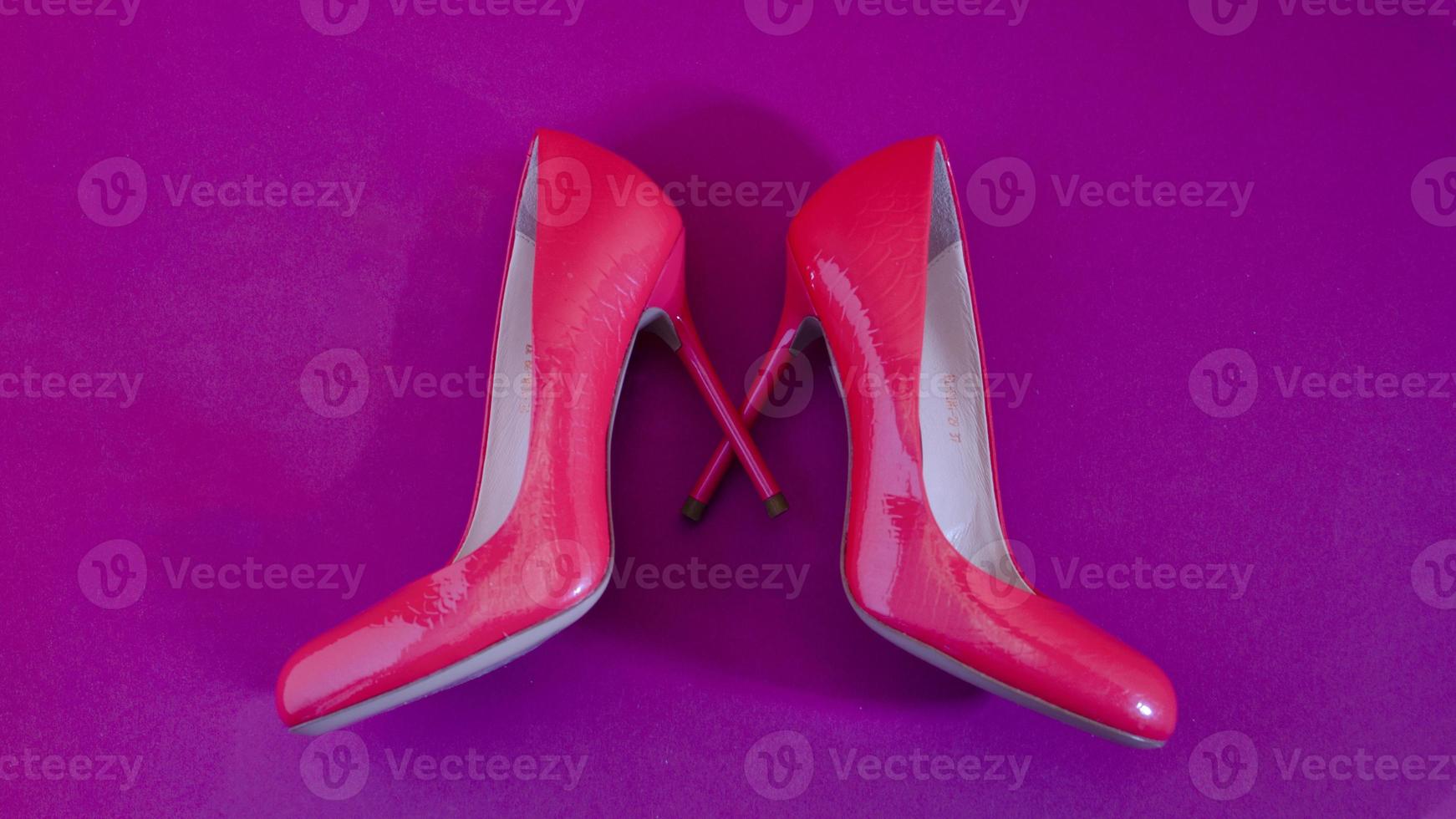 Elegant classic shoes close-up. Bright pink high heeled shoes. Pink and violet background. photo