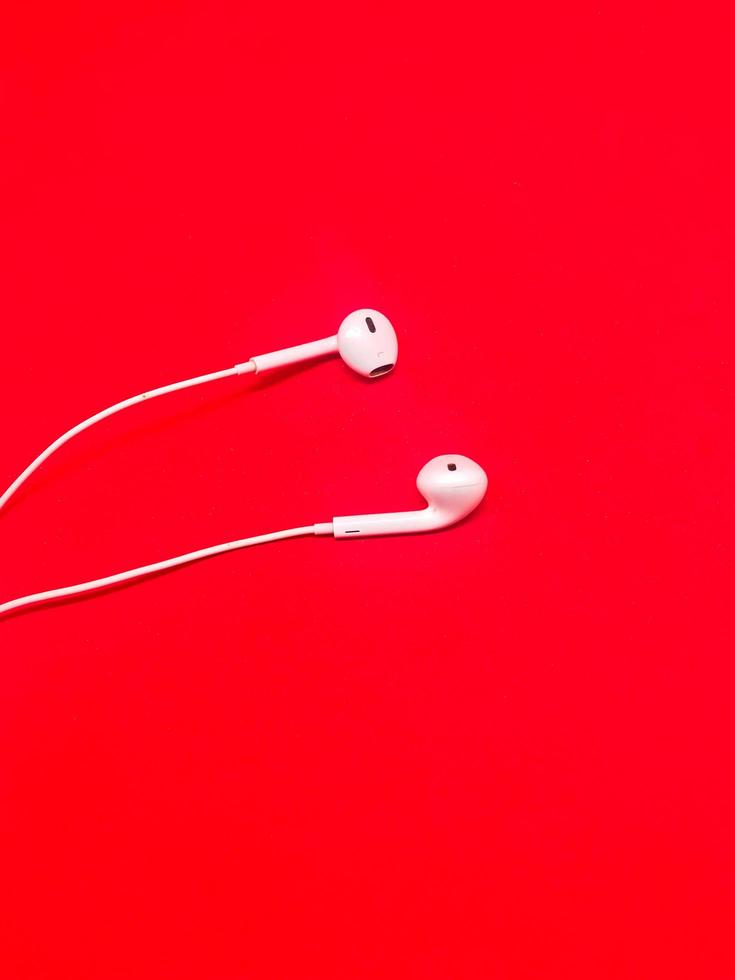 Insulated White Earphones with Red background photo