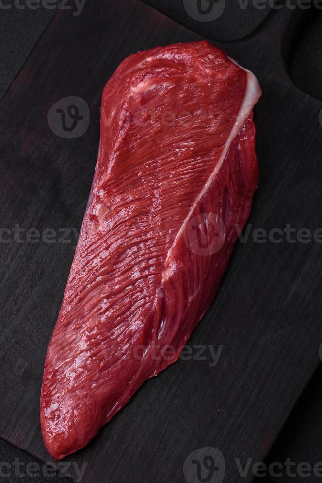 hermosa Fresco pedazo de crudo carne de vaca en un de madera corte tablero foto