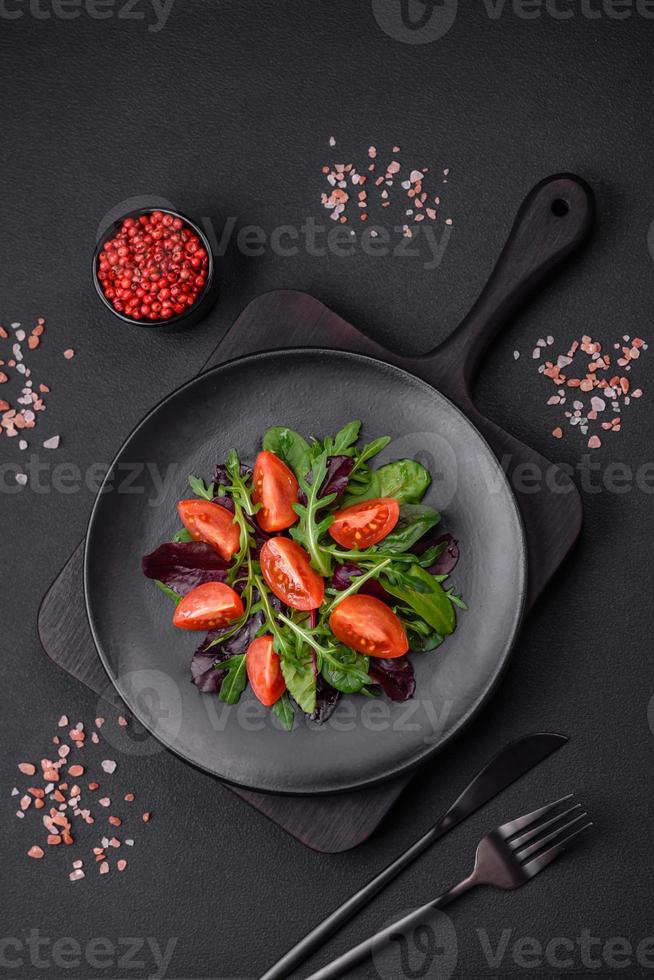 Salad of fresh cherry tomatoes, arugula, spinach and young beet leaves photo