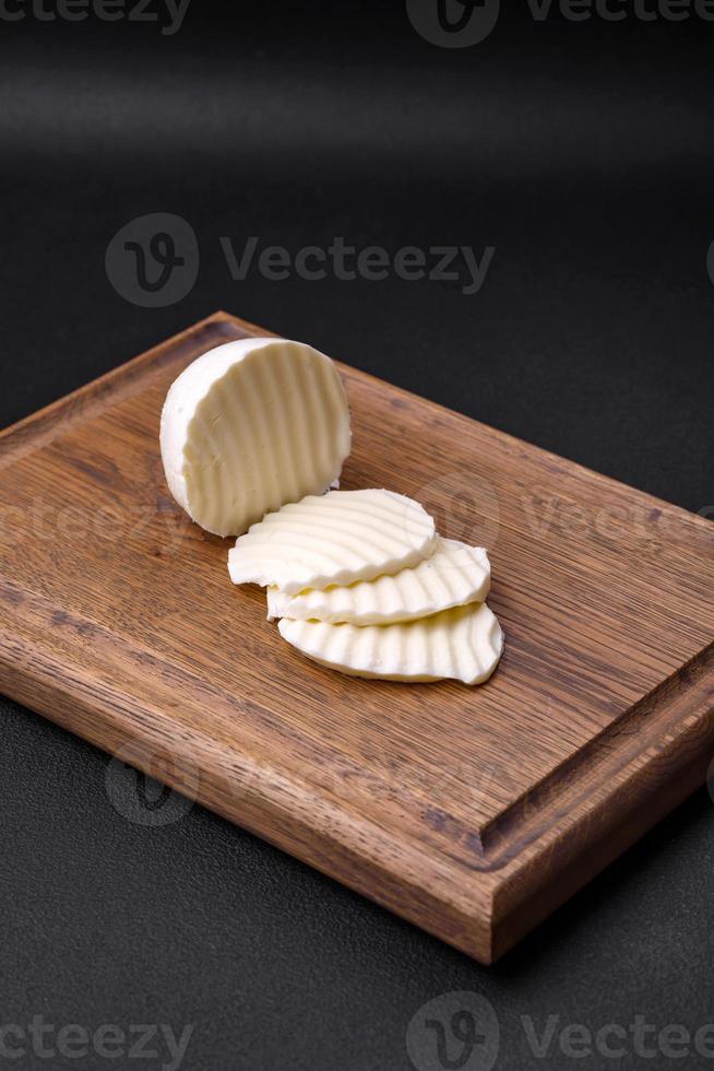 delicioso Fresco queso Mozzarella cortar dentro rebanadas en un de madera corte tablero foto