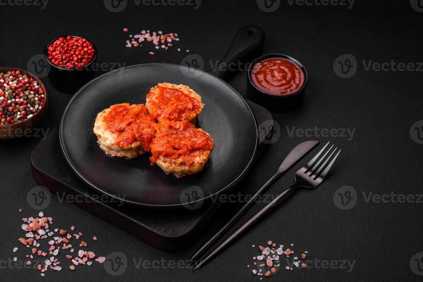 Delicious fresh cutlets or meatballs with spices, herbs and tomato sauce photo