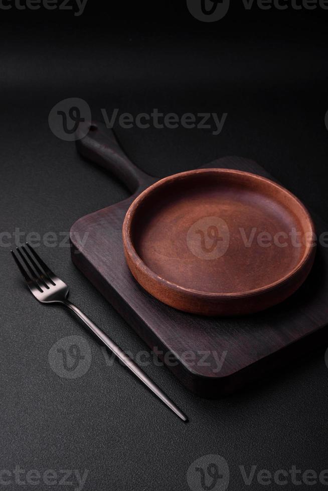 Empty brown colored ceramic plate on dark concrete background photo