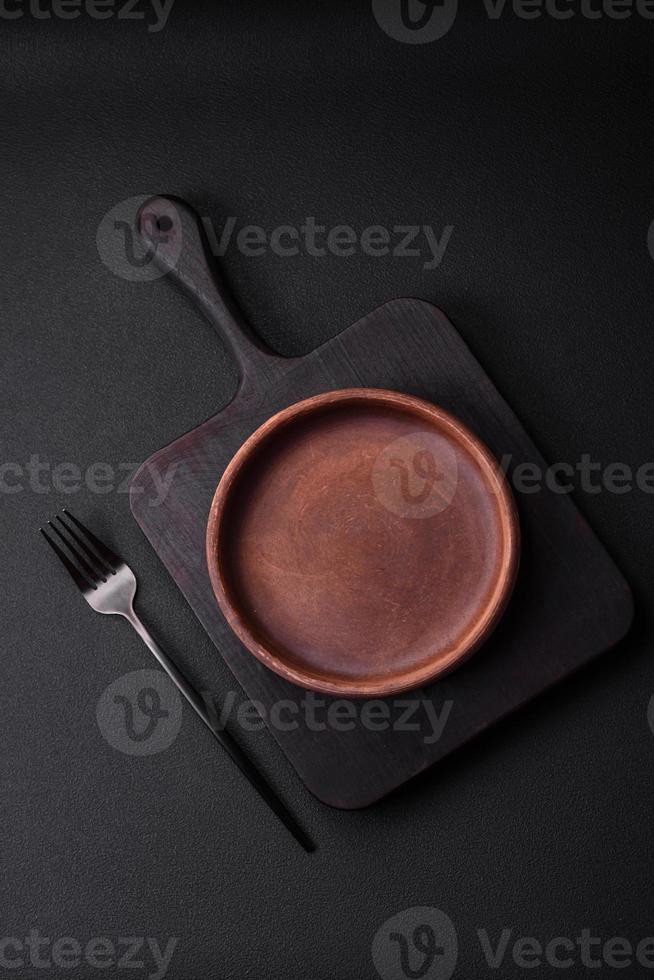 Empty brown colored ceramic plate on dark concrete background photo