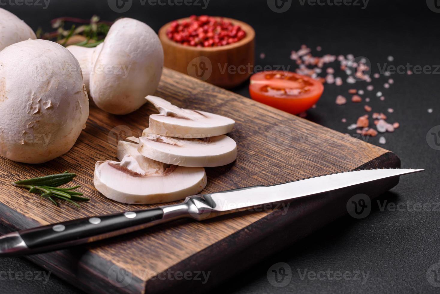 Fresco crudo champiñón hongos en un de madera corte tablero con especias foto