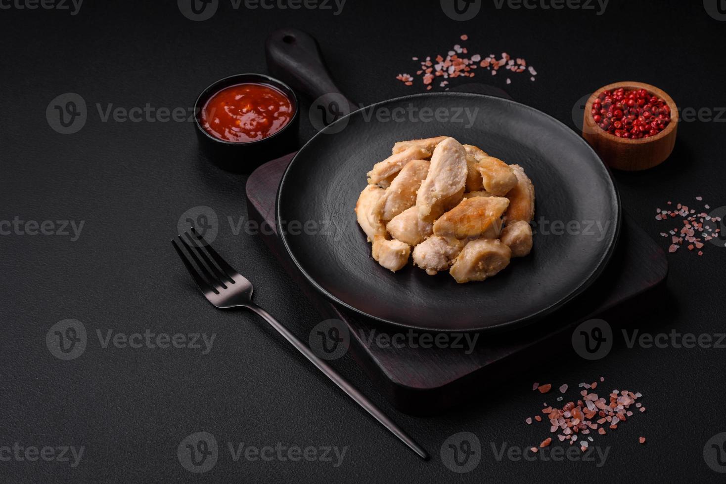 Delicious chicken slices baked with spices and herbs on a round ceramic plate photo