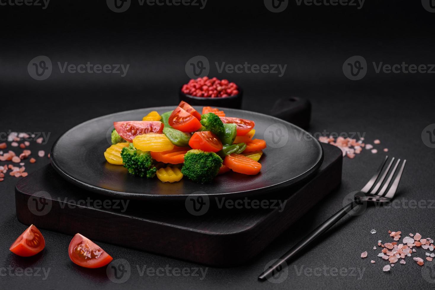 Salad of fresh and steamed vegetables cherry tomatoes, broccoli and carrots photo