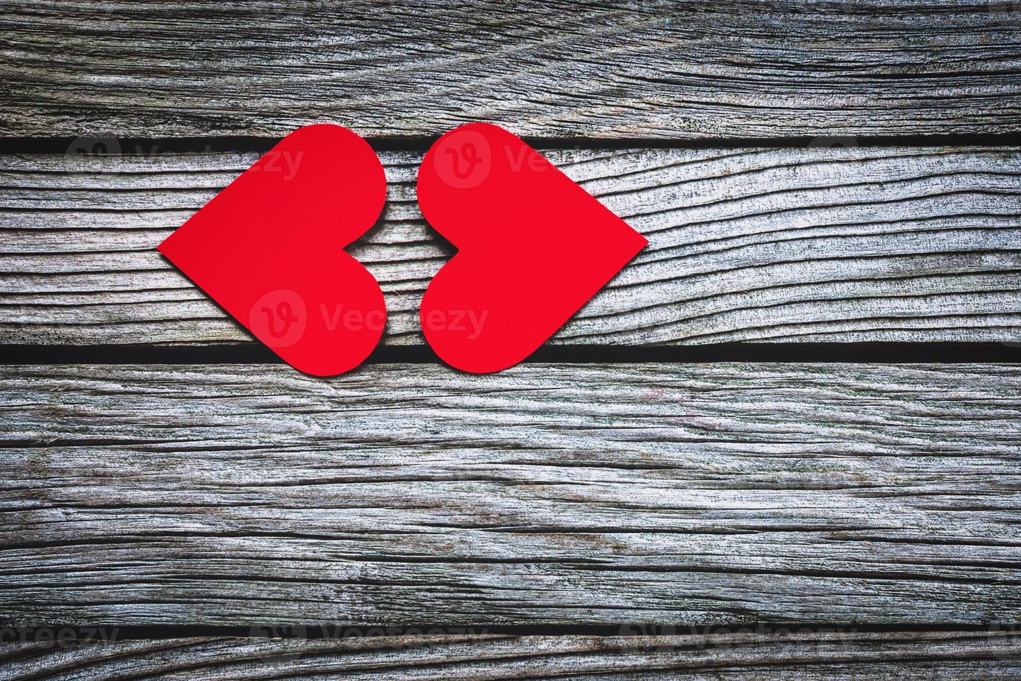 Two red hearts kissing on wooden background photo