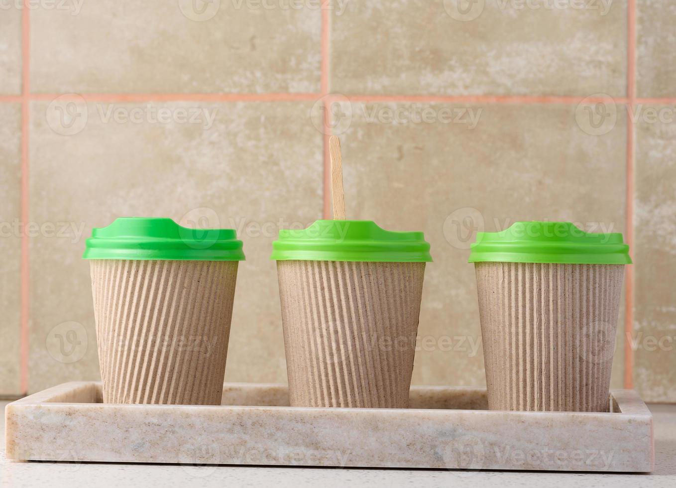 Paper brown cups with a plastic green lid for coffee and tea photo