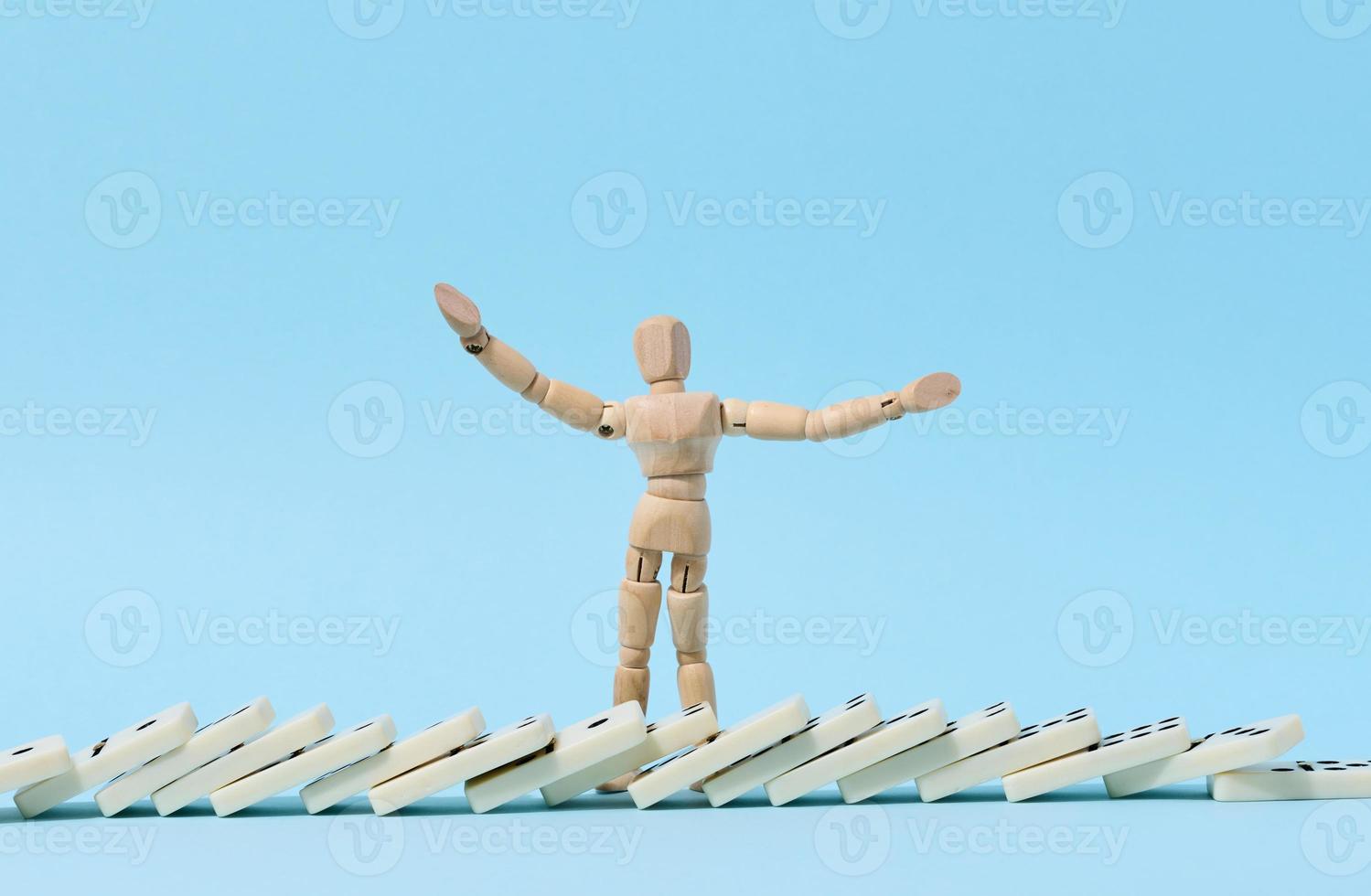 Wooden puppet and fallen domino, concept of failure and collapse photo