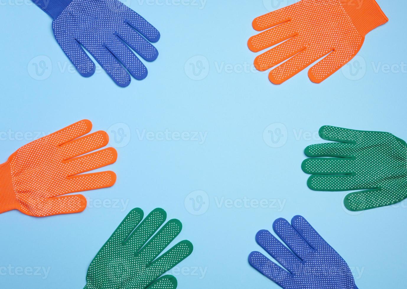Textile work gloves on a blue background. Protective clothing for manual workers, top view photo