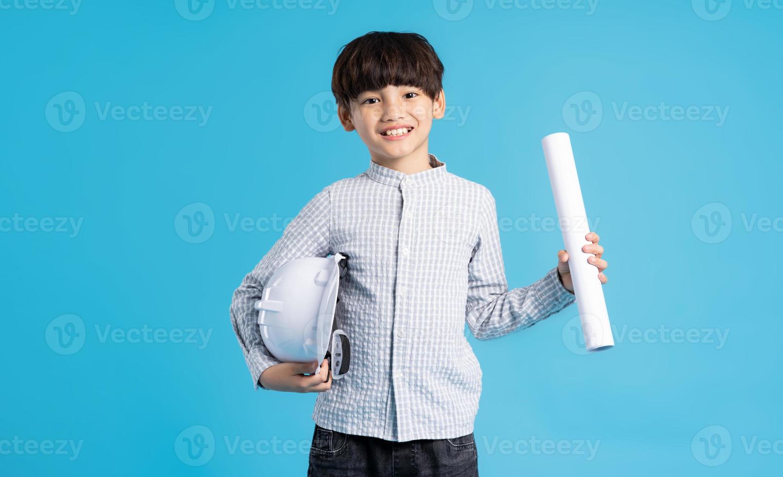 asiático chico retrato jugando el papel de un ingeniero, aislado en azul antecedentes foto