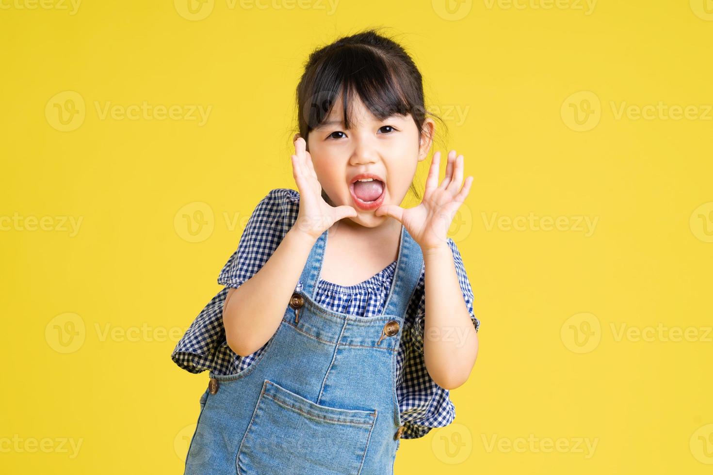 portrait of a beautiful asian girl, isolated on yellow background photo