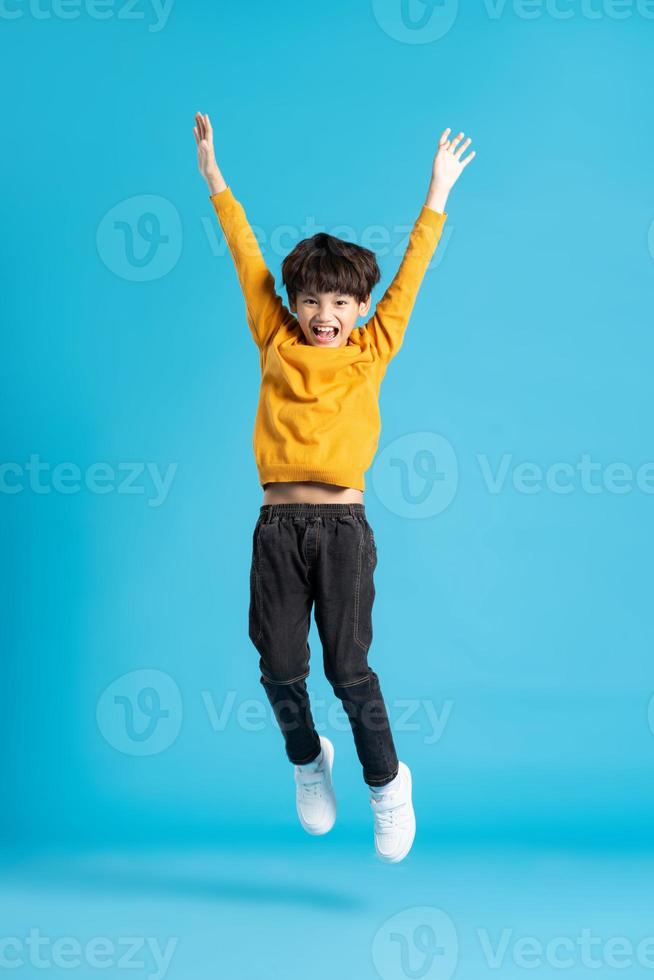 full body image of asian boy posing on blue background photo