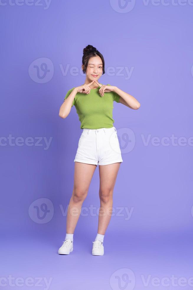 full body image of beautiful asian girl posing on pink background photo