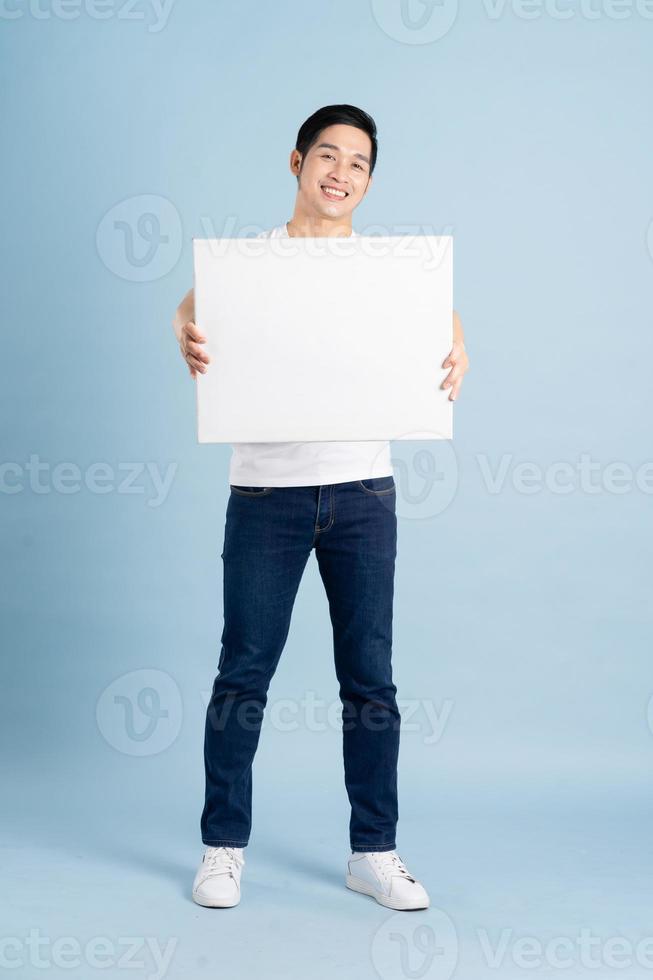 retrato de asiático hombre posando en azul antecedentes foto