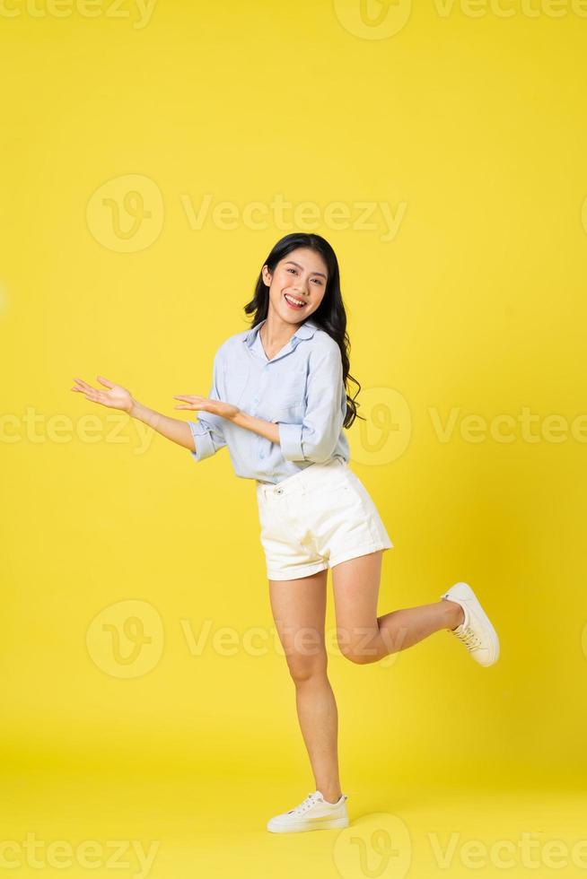 full body image of beautiful asian girl, isolated on yellow background photo