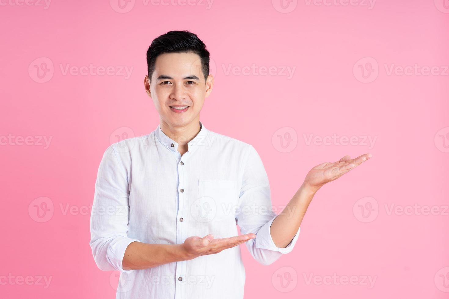 portrait of asian man posing on pink background photo