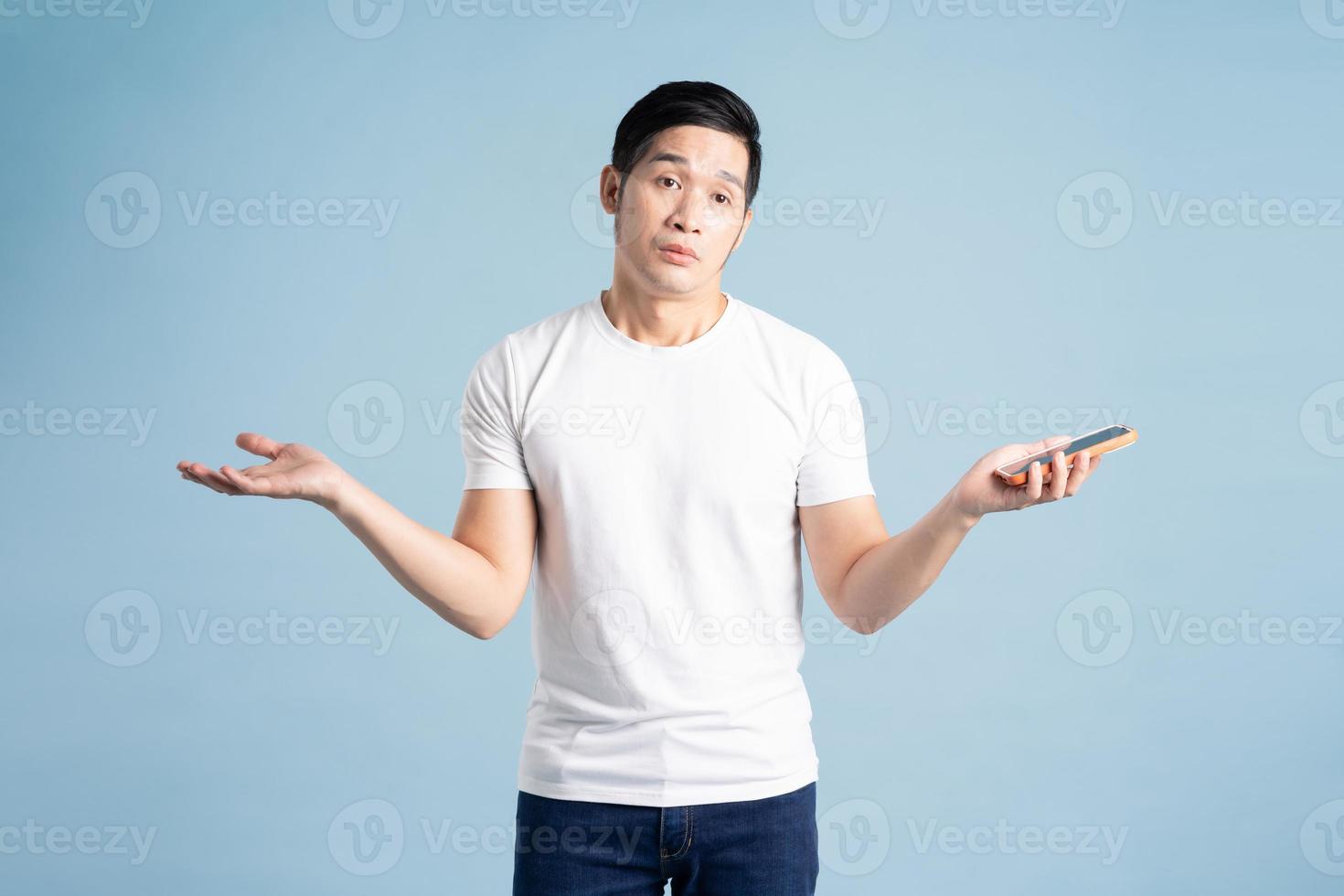 portrait of asian man posing on blue background photo