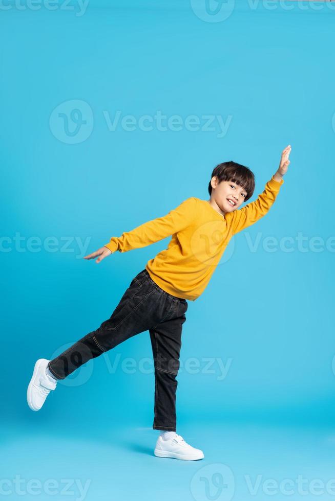full body image of asian boy posing on blue background photo