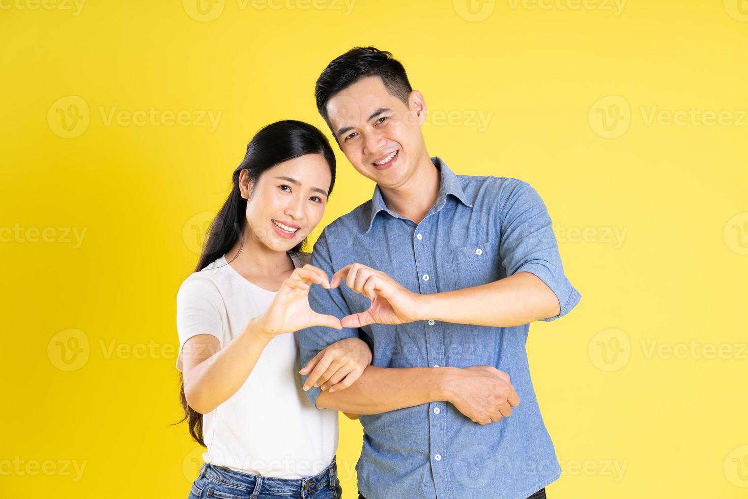 image of asian couple posing on yellow background photo