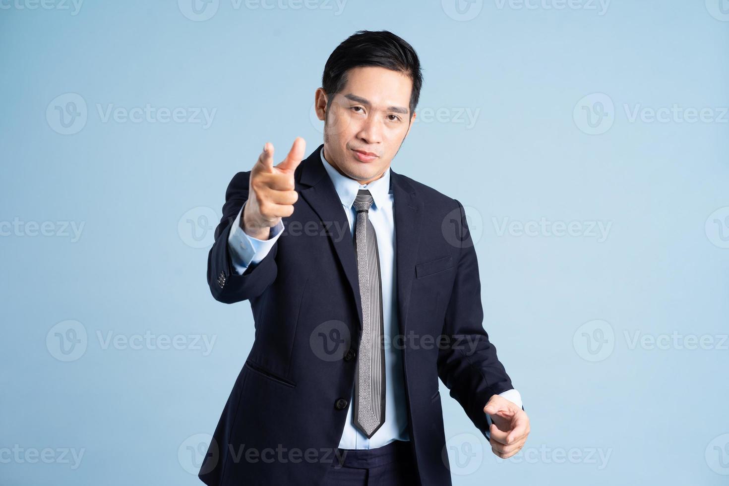 portrait of asian businessman wearing suit on blue background photo