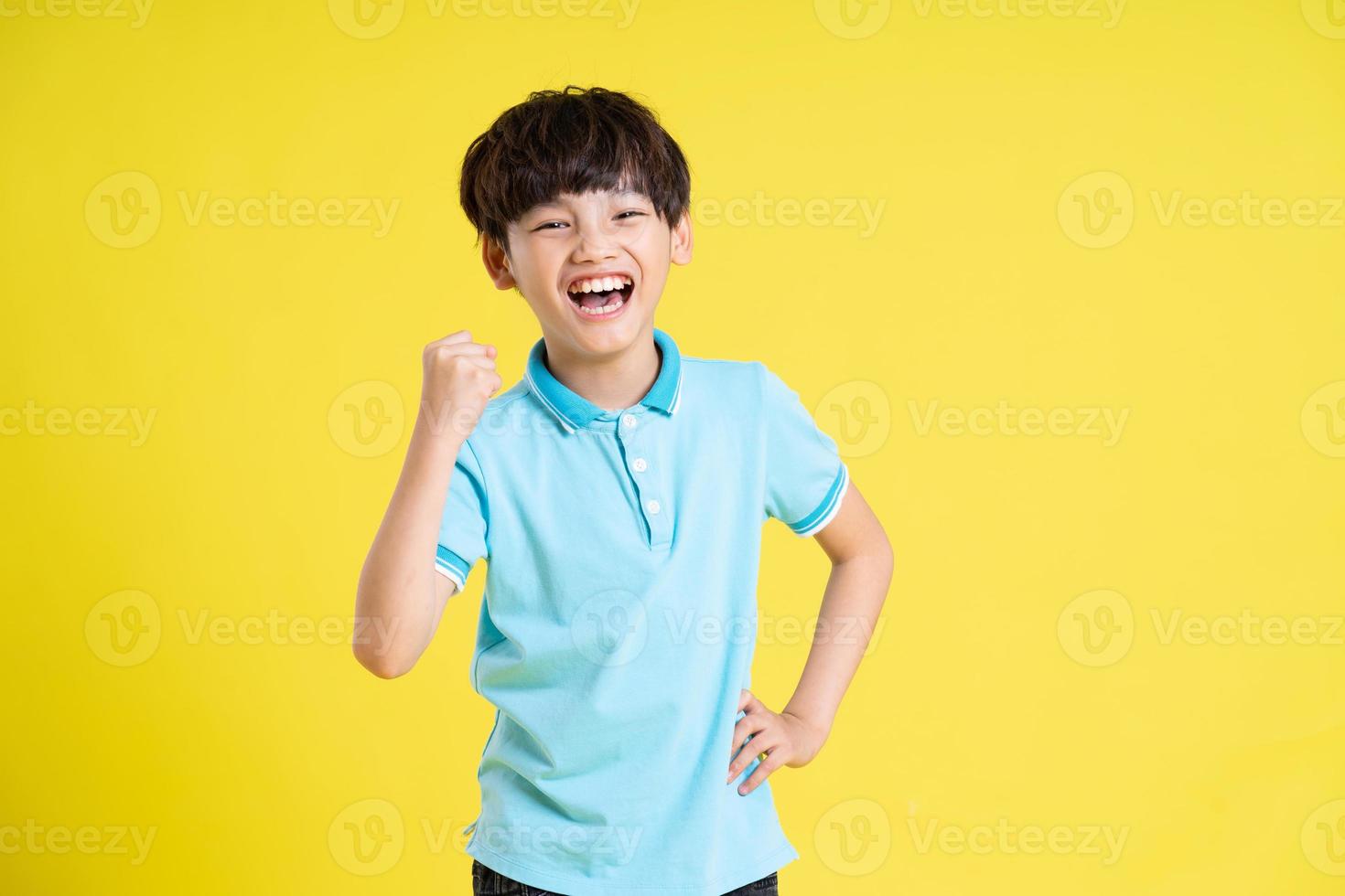 portrait of an asian boy posing on a yellow background photo