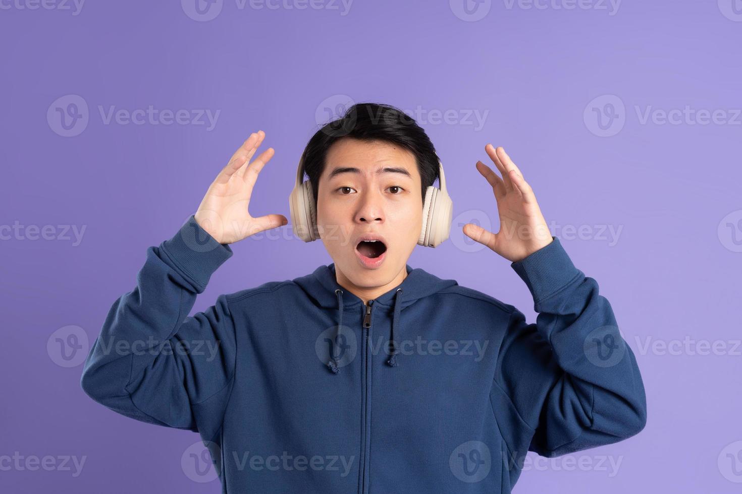 retrato de asiático hombre posando en púrpura antecedentes foto