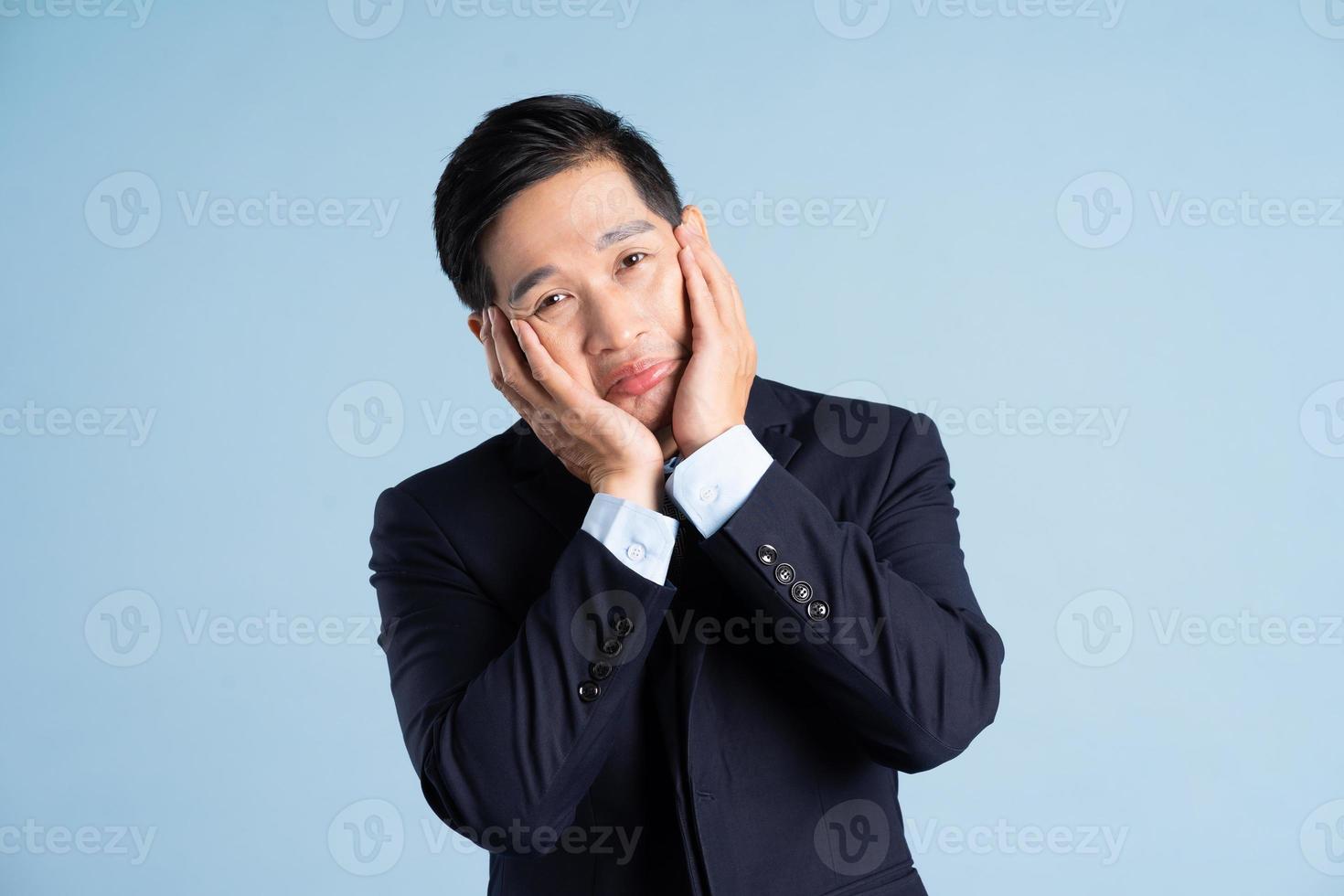 retrato, de, asiático, hombre de negocios, llevando, traje, en, fondo azul foto