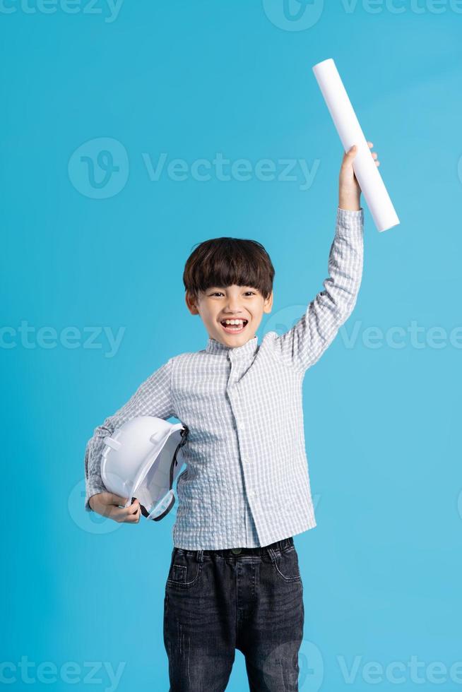 asiático chico retrato jugando el papel de un ingeniero, aislado en azul antecedentes foto