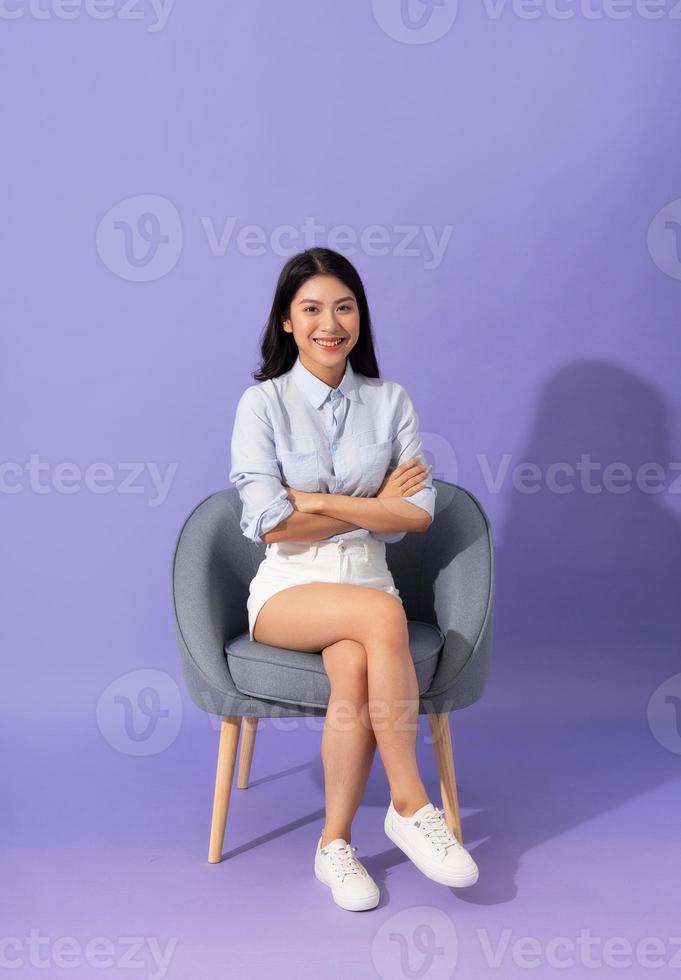 imagen de niña sentado en sofá aislado en púrpura antecedentes foto