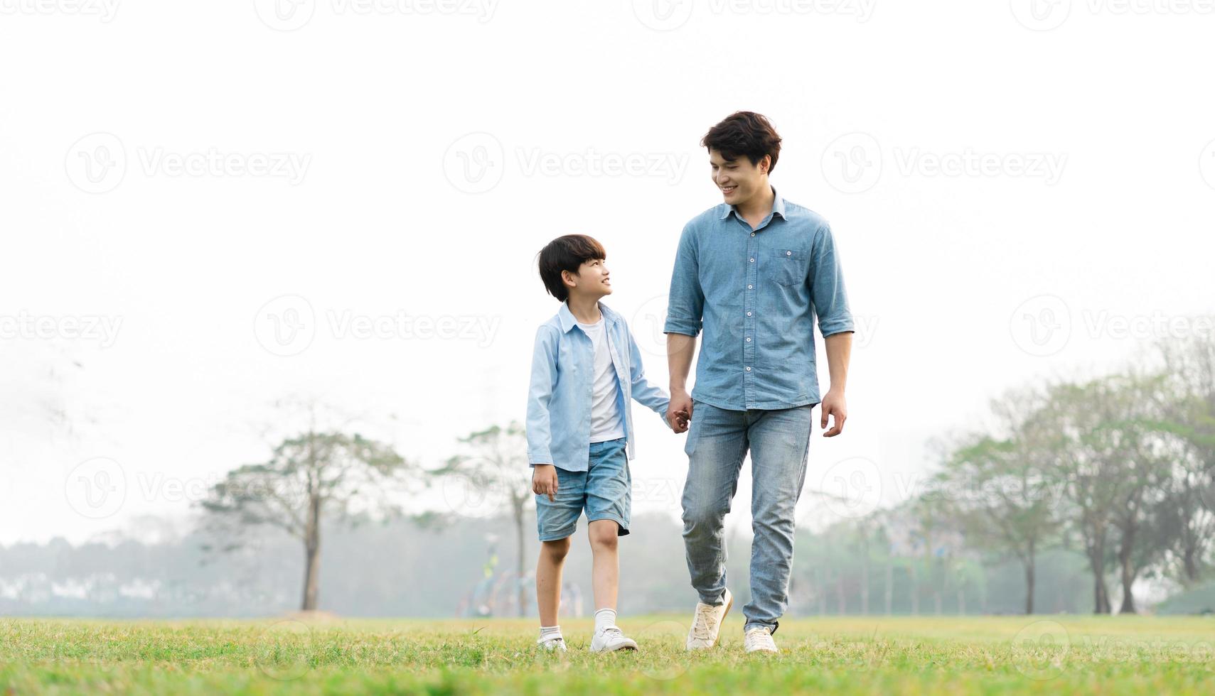 image of an asian father and son having fun in the park photo