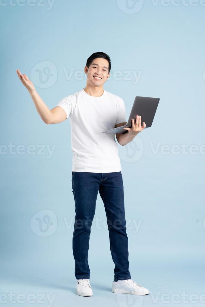 portrait of asian man posing on blue background photo