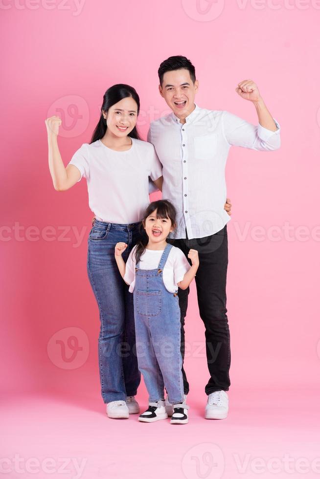 young asian family image isolated on pink background photo