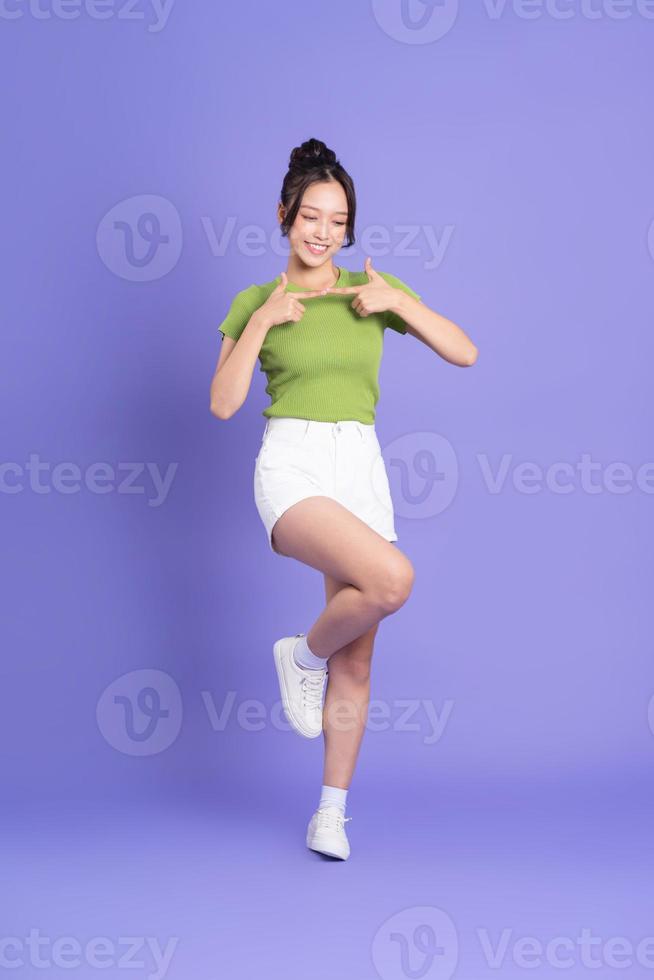 full body image of beautiful asian girl posing on pink background photo