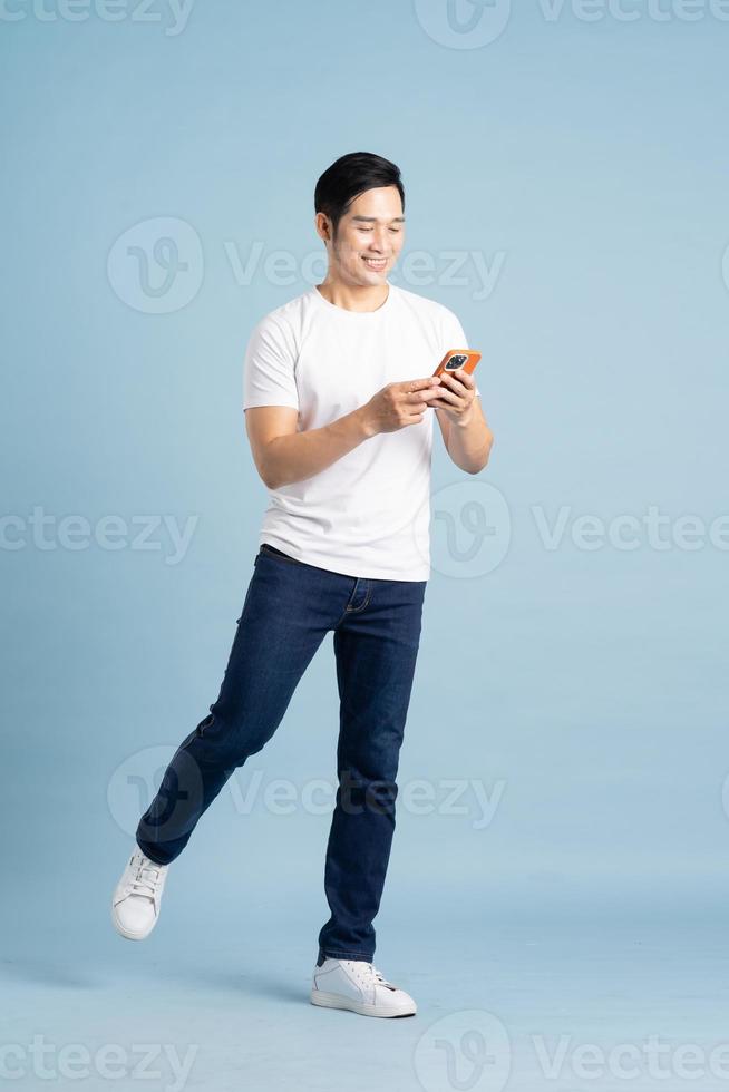 portrait of asian man posing on blue background photo