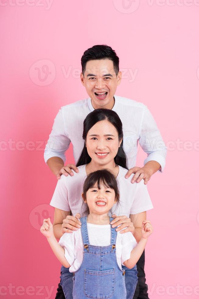 imagen feliz de la familia asiática joven, aislada en el fondo rosa foto