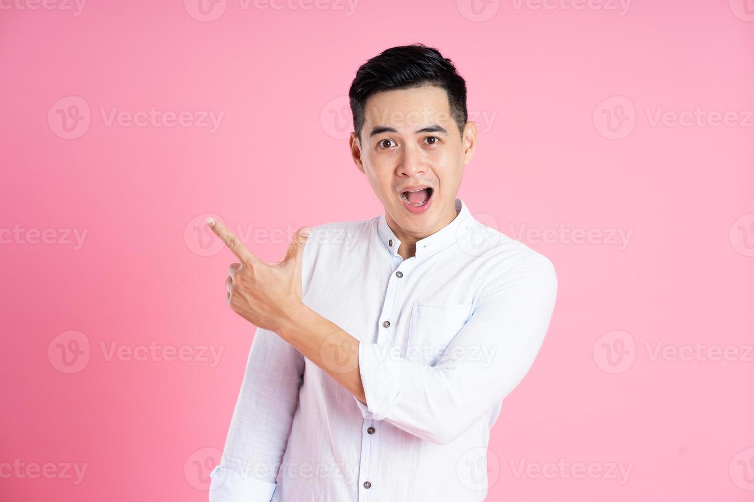 retrato de hombre asiático posando sobre fondo rosa foto