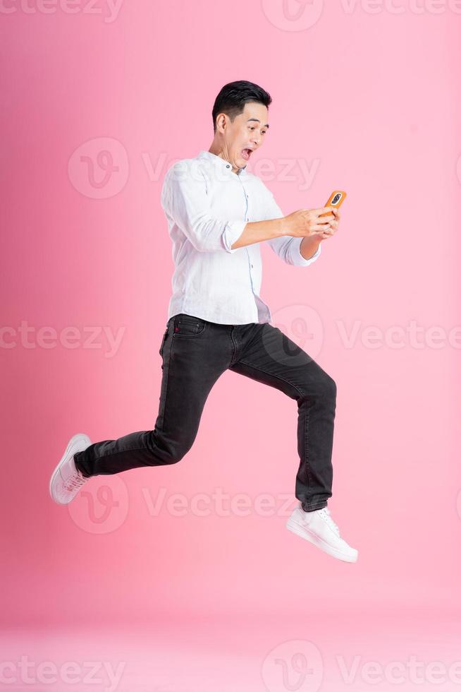 Asian man full body image, isolated on pink background photo