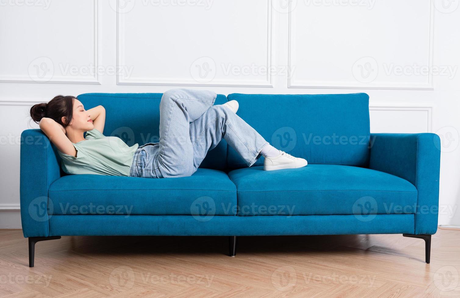 image of young Asian girl sitting on sofa at home photo