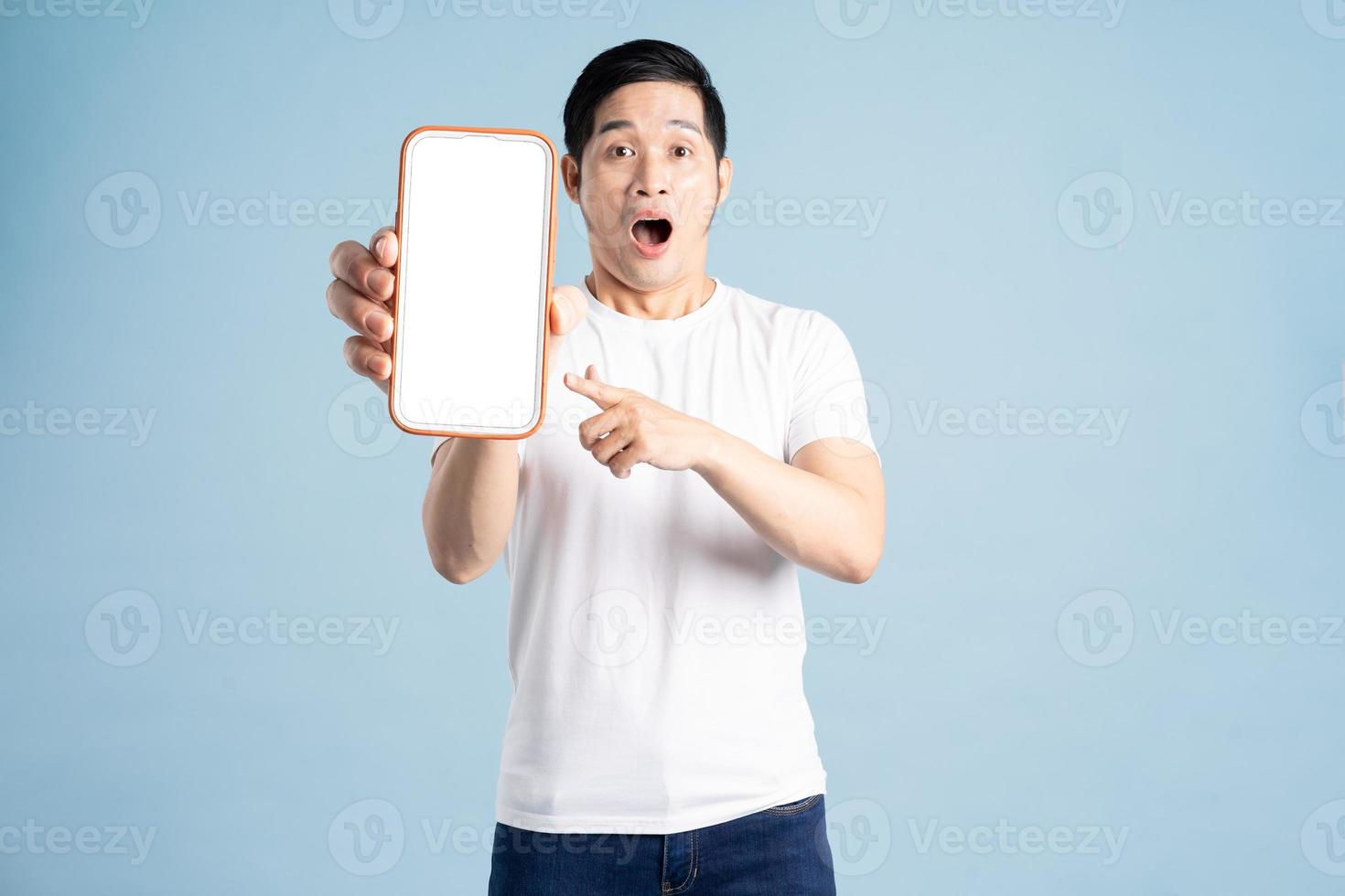 retrato de asiático hombre posando en azul antecedentes foto