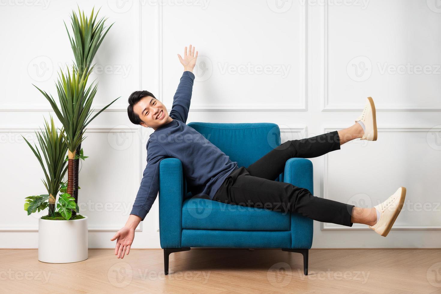 portrait of asian man sitting on sofa at home photo