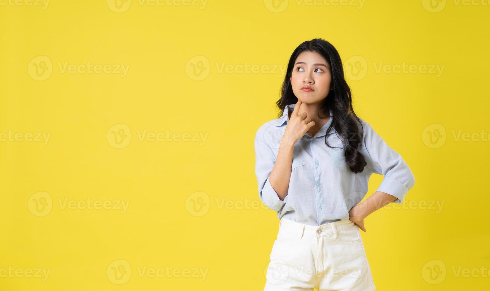 retrato de hermosa asiático niña posando en amarillo antecedentes foto