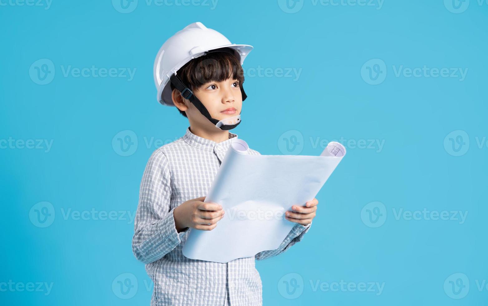 asiático chico retrato jugando el papel de un ingeniero, aislado en azul antecedentes foto
