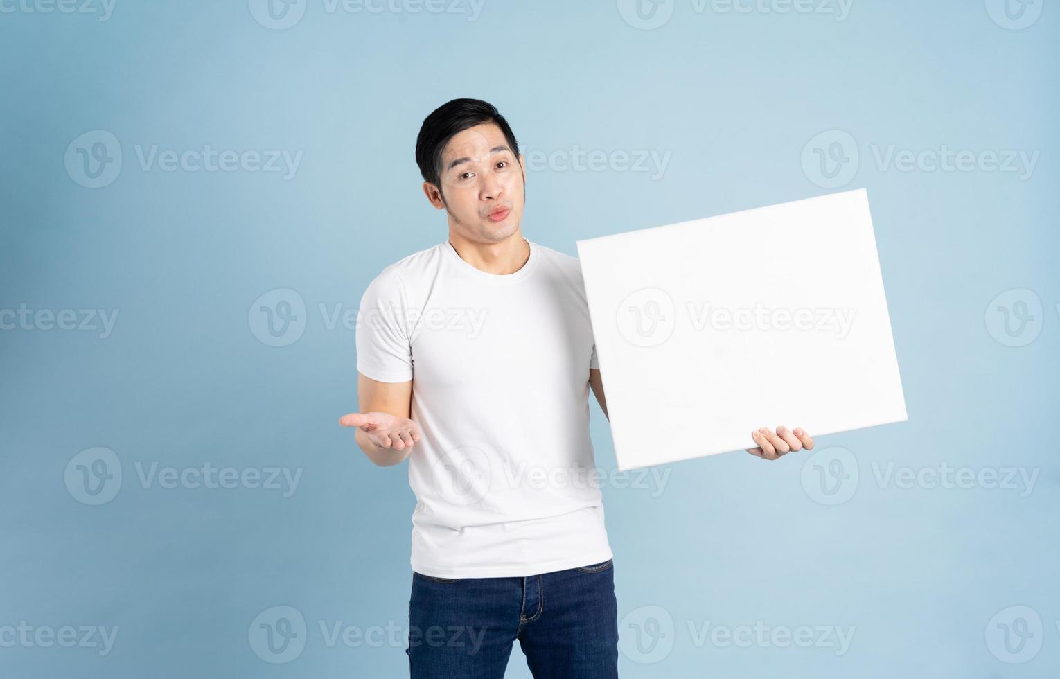 retrato de asiático hombre posando en azul antecedentes foto