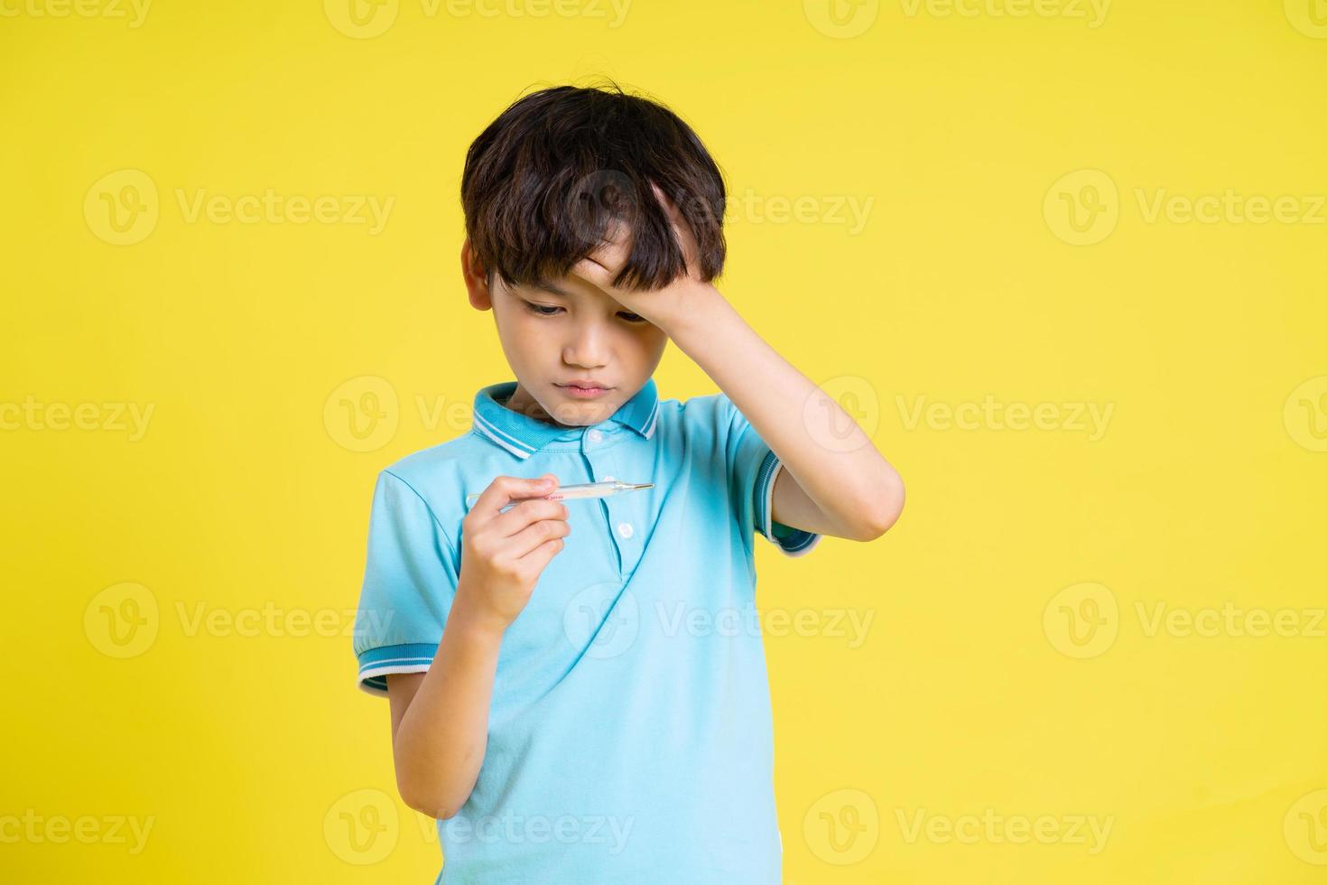 portrait of an asian boy posing on a yellow background photo