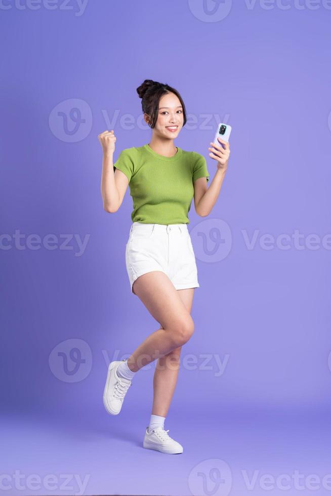 full body image of beautiful asian girl posing on pink background photo