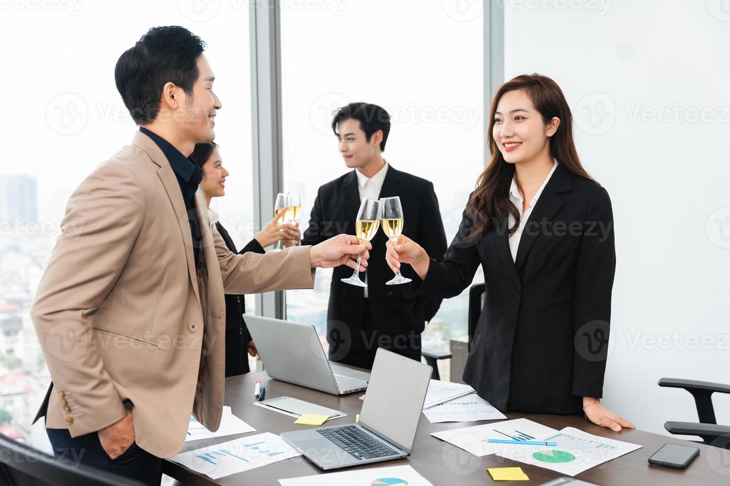 group of Asian business people holding glasses of wine to celebrate new year photo