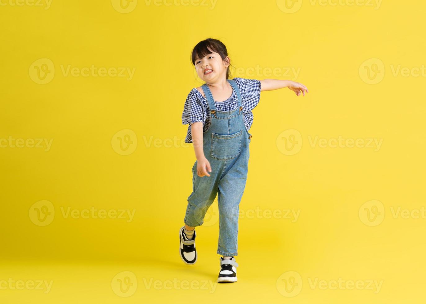 full body image of beautiful asian baby girl on yellow background photo