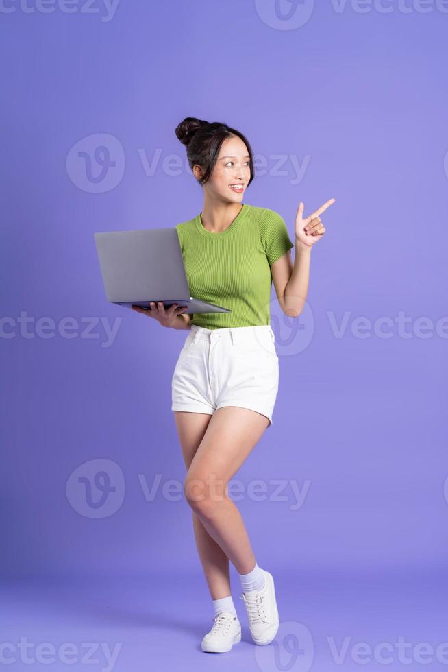 full body image of beautiful asian girl posing on pink background photo